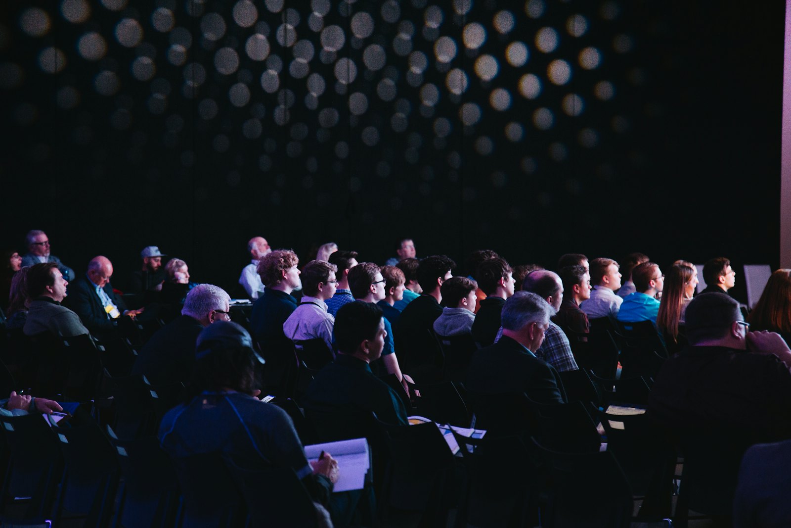 Conference audience watching a keynote in a darkened hall